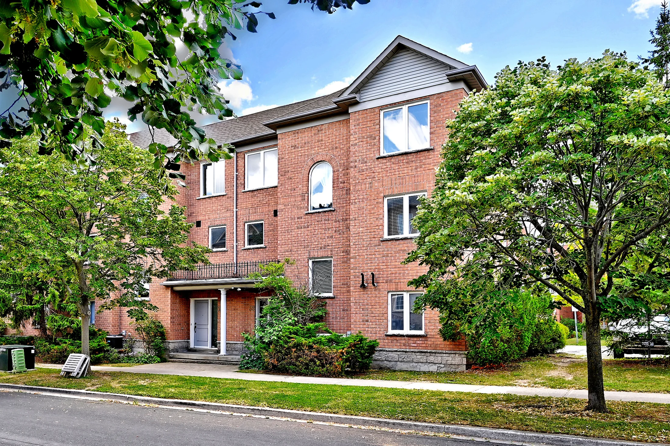 Brick corner townhome framed by mature trees